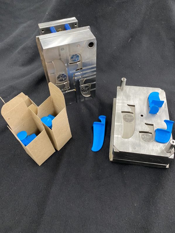 The HairFin mold with blue sample parts and retail packaging